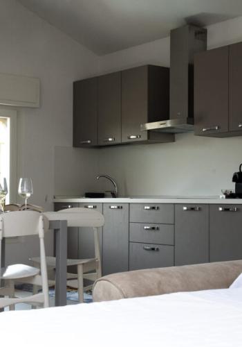 Cucina moderna e luminosa, con tavolo accogliente e letto invitante.