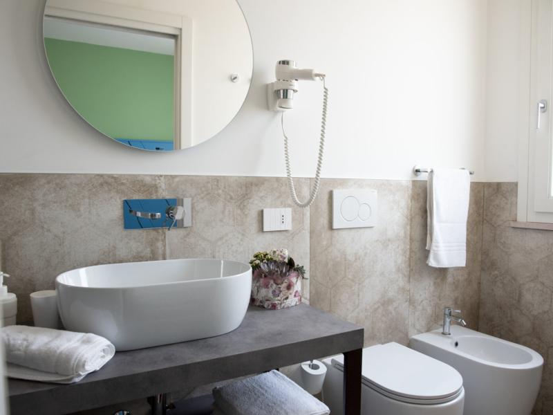 Bagno moderno e luminoso, con lavabo elegante e dettagli curati, atmosfera rilassante.